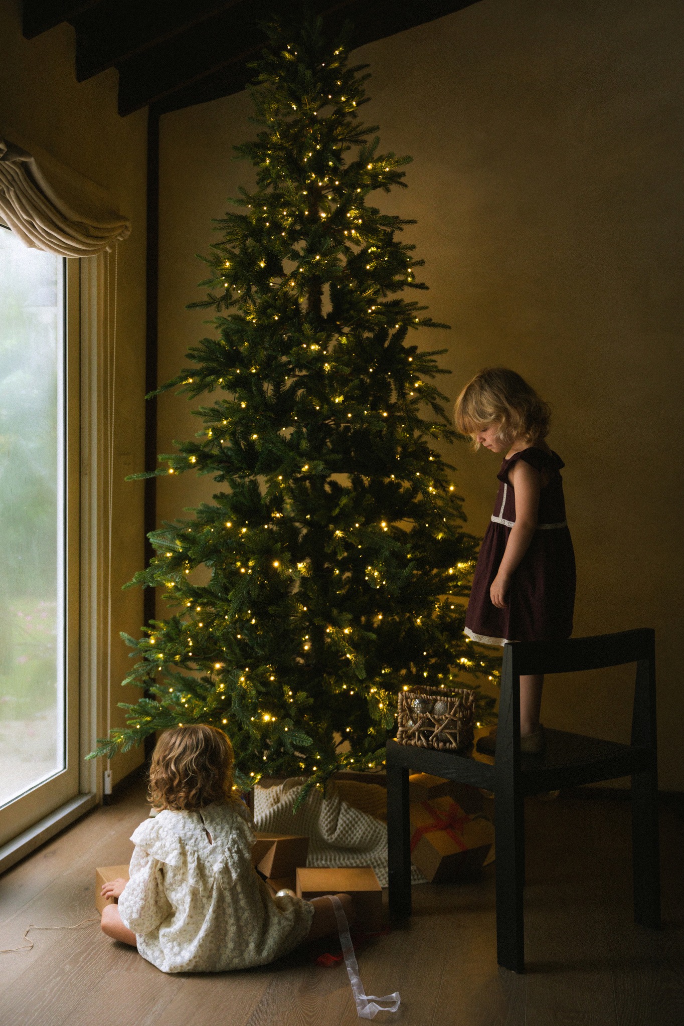 Dos niñas decoran el árbol de Navidad