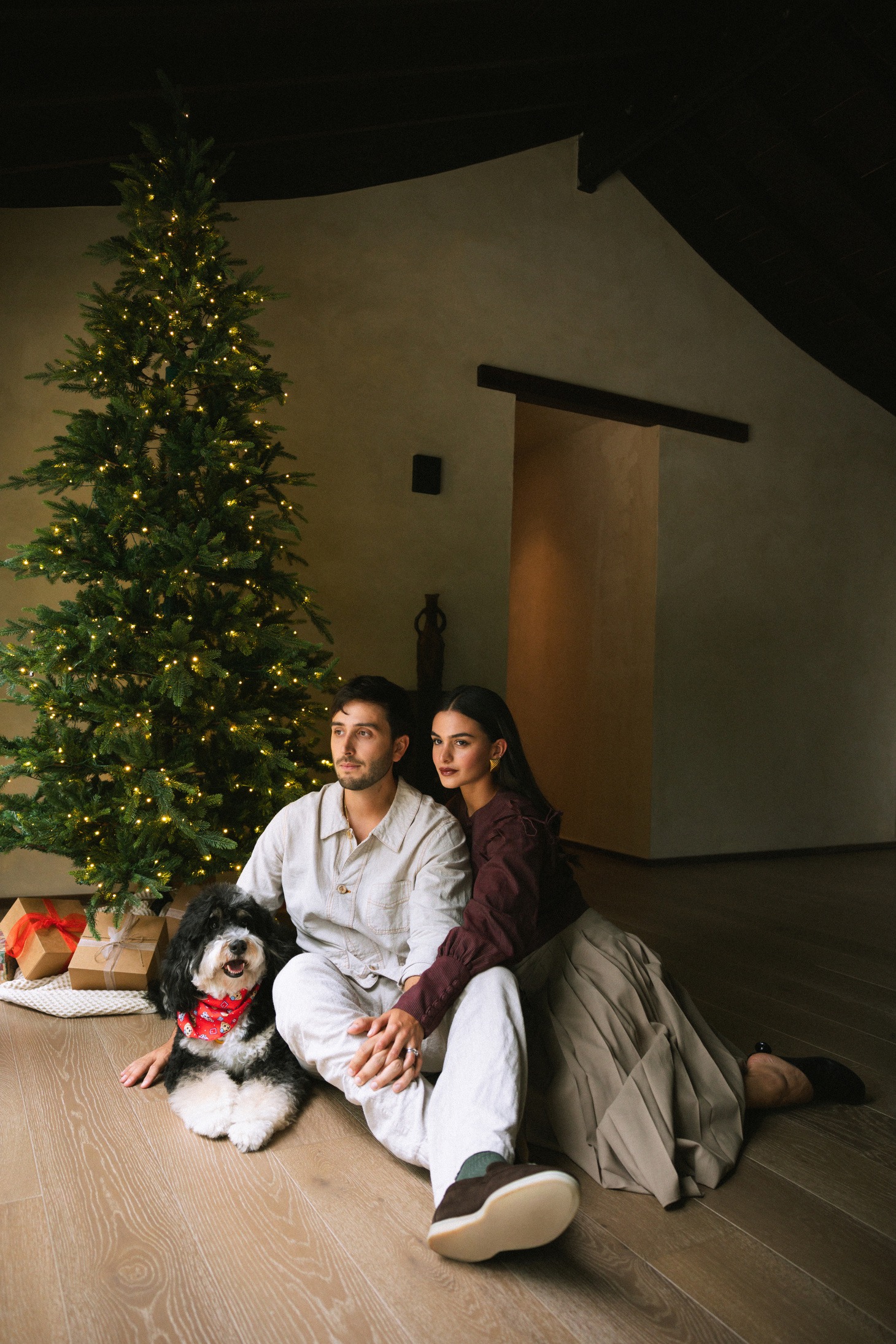 Una pareja con su perro frente al árbol