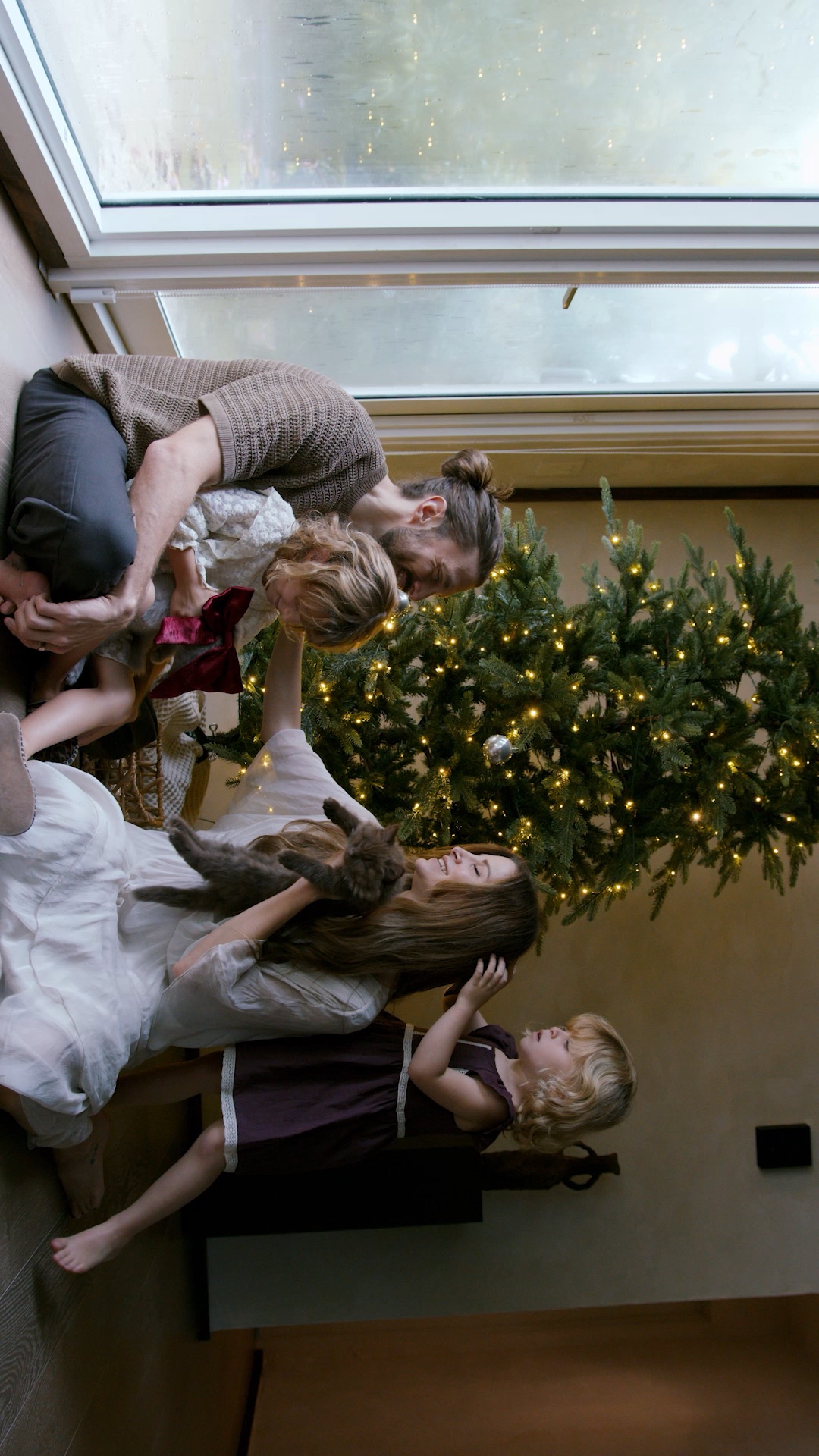 Una familia comparte un momento junto al árbol de Navidad