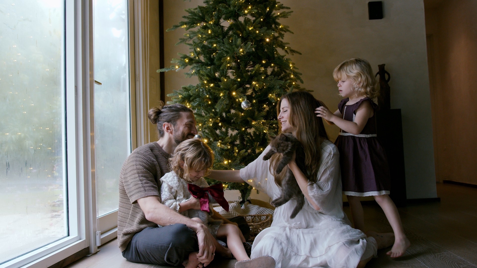 Una familia reunida junto al árbol de Navidad
